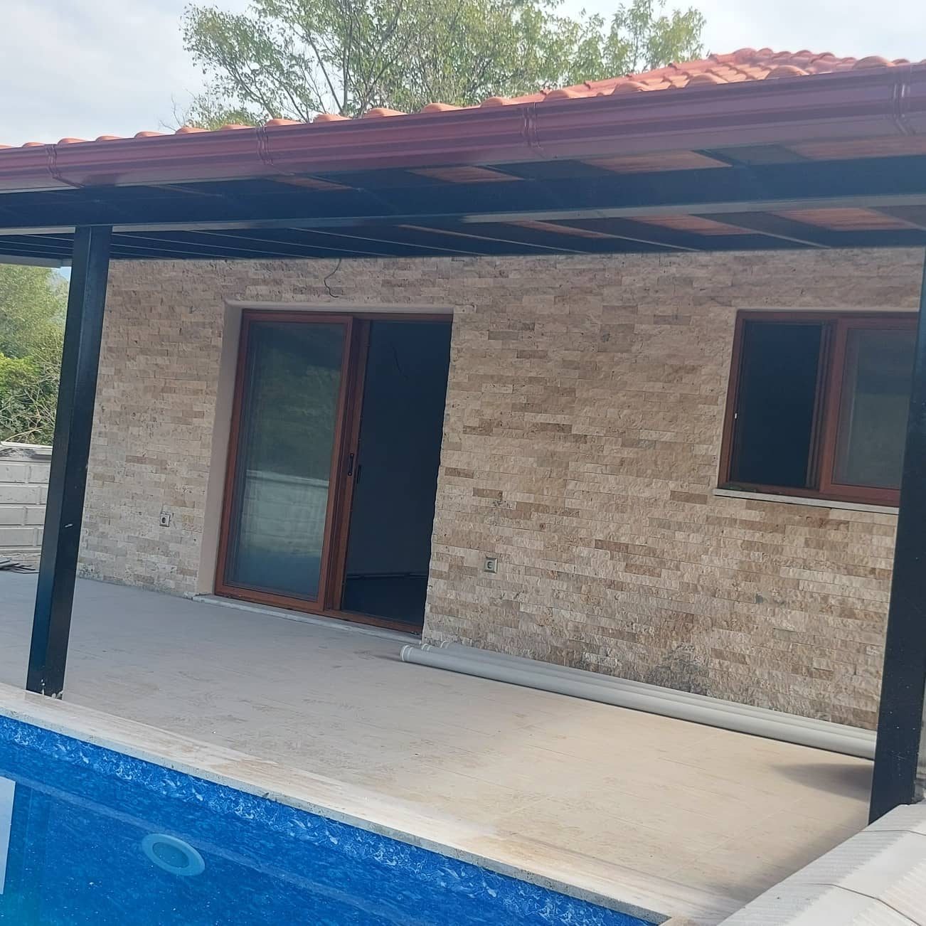 Taş cepheli ev, havuz ve pergola